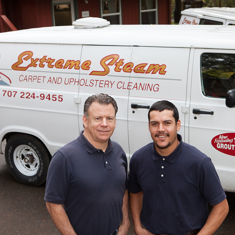 Photo of the owner and an employee smiling outside of an Extreme Steam service van.